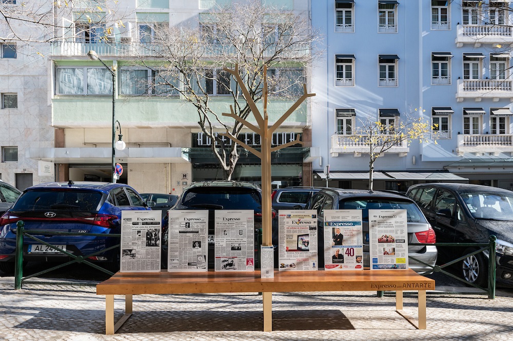 Banco oferecido à cidade, decorado com algumas das capas emblemáticas do jornal - junto ao nº 37 da Rua Duque de Palmela Banco oferecido à cidade, decorado com algumas das capas emblemáticas do jornal - junto ao nº 37 da Rua Duque de Palmela