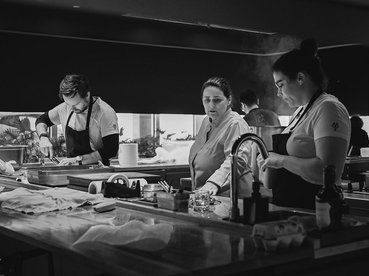 Chef Marlene na bancada a falar com os seus cozinheiros